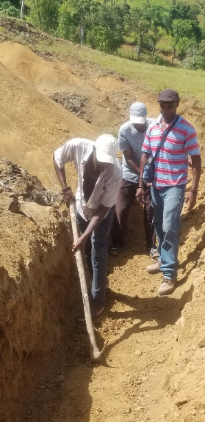 Réné walks along a trench demonstrating how deep they have to be. Now consider how much digging it takes to plant half a million trees every year!